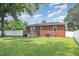 Spacious backyard featuring a well-maintained lawn, and a view of the brick house at 208 S College Ave, Kenly, NC 27542