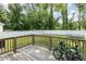 Backyard view from wooden deck, featuring a fenced yard and tree line at 208 S College Ave, Kenly, NC 27542