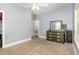 Carpeted bedroom with neutral walls, ceiling fan, dresser, and a view of bathroom entrance at 208 S College Ave, Kenly, NC 27542