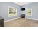 Bedroom featuring carpeted floors, two windows, and a modern ceiling fan at 208 S College Ave, Kenly, NC 27542