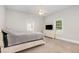 Well-lit bedroom with neutral tones, carpeted floor, ceiling fan, and two windows at 208 S College Ave, Kenly, NC 27542