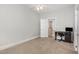 Bright, carpeted bedroom featuring a ceiling fan and desk area, next to a bathroom at 208 S College Ave, Kenly, NC 27542