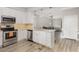 Modern kitchen boasts stainless steel appliances, granite counters, and seamless open layout to the dining area at 208 S College Ave, Kenly, NC 27542