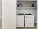 Bright laundry room featuring a washer and dryer, with shelving for storage at 208 S College Ave, Kenly, NC 27542