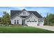 Charming two-story home featuring a three-car garage, light blue siding and a well-manicured lawn at 2129 Abbeyhill Dr # 89, Raleigh, NC 27610