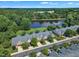 Scenic aerial view showcasing townhomes surrounded by a lush green landscape and a peaceful lake at 240 Meadow Beauty Dr, Apex, NC 27539