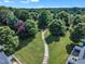 Aerial view showcasing a paved community walking path lined with colorful trees and landscaping at 240 Meadow Beauty Dr, Apex, NC 27539