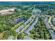 Aerial view of the community with a pond, mature trees, and well-maintained residential streets at 240 Meadow Beauty Dr, Apex, NC 27539