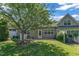 Backyard patio with manicured lawn leading to home with neutral siding and white trim windows at 240 Meadow Beauty Dr, Apex, NC 27539