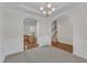 Elegant dining room featuring an arched doorway, chandelier, and wainscoting at 240 Meadow Beauty Dr, Apex, NC 27539