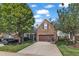 Attractive townhome with a stone exterior, two-car garage, and a beautifully landscaped front yard at 240 Meadow Beauty Dr, Apex, NC 27539