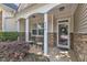 Welcoming front porch with decorative columns, seating, and a beautifully adorned front door at 240 Meadow Beauty Dr, Apex, NC 27539