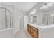 The main bathroom provides double sinks, large mirrors, a glass shower, and a separate tub at 240 Meadow Beauty Dr, Apex, NC 27539