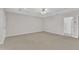 A neutral, carpeted room featuring a ceiling fan and access to the main bathroom at 240 Meadow Beauty Dr, Apex, NC 27539