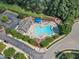 Aerial view of the neighborhood pool with plenty of lounge seating, a playground, and nearby parking at 240 Meadow Beauty Dr, Apex, NC 27539