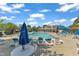 Large neighborhood pool area with a clubhouse, lounge seating, and blue sun umbrellas at 240 Meadow Beauty Dr, Apex, NC 27539