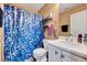 Bathroom features a shower with blue patterned curtain and white vanity at 2501 Springfield Park Dr, Raleigh, NC 27614