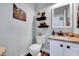 Stylish half bath featuring modern vanity, attractive shelving, and modern fixtures at 2501 Springfield Park Dr, Raleigh, NC 27614