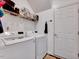 Bright laundry room with modern washer, dryer, storage shelf and tiled floor at 2501 Springfield Park Dr, Raleigh, NC 27614
