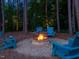 Cozy backyard fire pit with Adirondack chairs surrounded by trees at night at 259 Brown Bear, Chapel Hill, NC 27517