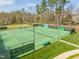 Community tennis courts surrounded by a secure fence, mature trees, and landscaping at 259 Brown Bear, Chapel Hill, NC 27517