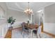 Dining room with hardwood floors, wainscoting, chandelier, and views into other rooms at 260 Easy Wind Ln, Garner, NC 27529