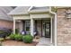 Inviting front porch with seating, decorative plants, brick accents, and stylish entrance details at 260 Easy Wind Ln, Garner, NC 27529