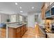 Open-concept kitchen features granite counters, stainless appliances, and a view to the sunroom at 260 Easy Wind Ln, Garner, NC 27529