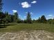 Expansive backyard with lush greenery, trees, and a clear blue sky at 2657 Joel Johnson Rd, Lillington, NC 27546