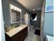 Well-lit bathroom featuring a vanity with ample storage and neutral-toned tile flooring at 2657 Joel Johnson Rd, Lillington, NC 27546