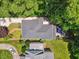 An aerial view of a home with a dark roof surrounded by trees, a patio, and a long driveway with a white car in the drive at 2725 Rosedale Ave, Raleigh, NC 27607