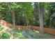 Landscaped backyard featuring a wooden fence, mature trees, and an outdoor fire pit seating area at 2725 Rosedale Ave, Raleigh, NC 27607