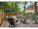 Cozy backyard patio with stone pavers, a fire pit, Adirondack chairs, and a wooden fence at 2725 Rosedale Ave, Raleigh, NC 27607