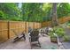 Backyard features a fire pit, Adirondack chairs, stone pavers, wooden fence, and mature trees at 2725 Rosedale Ave, Raleigh, NC 27607