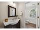 Lovely bathroom with a dark wood vanity, a decorative mirror, and an arched window adding natural light at 2725 Rosedale Ave, Raleigh, NC 27607