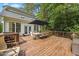 Wooden deck features a dining table, umbrella, wrought iron railing, and the back exterior of the home at 2725 Rosedale Ave, Raleigh, NC 27607