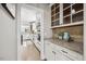 Butlers pantry leading to kitchen with stainless appliances, granite counters, and white custom cabinetry at 2725 Rosedale Ave, Raleigh, NC 27607