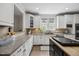 Spacious kitchen featuring white cabinetry, stone countertops, and stainless steel appliances at 2725 Rosedale Ave, Raleigh, NC 27607