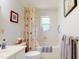 Cozy bathroom features a bathtub, floral shower curtain, and ample natural light, creating a serene space at 2816 Shepard School Rd, Zebulon, NC 27597