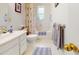 Bright bathroom featuring a bathtub, a floral shower curtain and a white vanity with drawers for storage at 2816 Shepard School Rd, Zebulon, NC 27597