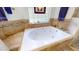 Bright bathroom features a luxurious white bathtub with mosaic tile accents and stained glass window at 2816 Shepard School Rd, Zebulon, NC 27597
