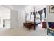 Bright bedroom with a four-poster bed by bay windows, white walls, and neutral carpet at 2816 Shepard School Rd, Zebulon, NC 27597
