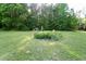 Well-maintained yard with a flower bed and mature trees at 2816 Shepard School Rd, Zebulon, NC 27597