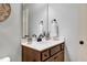 Stylish bathroom features a wood vanity with a white countertop, decorative mirror, and modern fixtures at 29 Laurel Ln, Youngsville, NC 27596