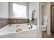 Bright bathroom featuring a soaking tub with tile surround and a separate shower at 29 Laurel Ln, Youngsville, NC 27596