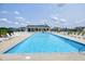 Large community pool with ample lounge chairs and a clubhouse in the background at 29 Laurel Ln, Youngsville, NC 27596