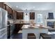 Open-concept kitchen with dark cabinets, granite countertops, an island, and stainless steel appliances at 29 Laurel Ln, Youngsville, NC 27596
