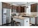 Modern kitchen features dark wood cabinetry, stainless steel appliances, and a granite countertop island with seating at 29 Laurel Ln, Youngsville, NC 27596