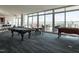 A game room boasts ample natural light, featuring a billiard table, and foosball table at 301 Fayetteville St # 2611, Raleigh, NC 27601