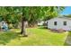 Backyard featuring a swing, play set, mature trees, and fire pit at 309 S Mckay Ave, Dunn, NC 28334